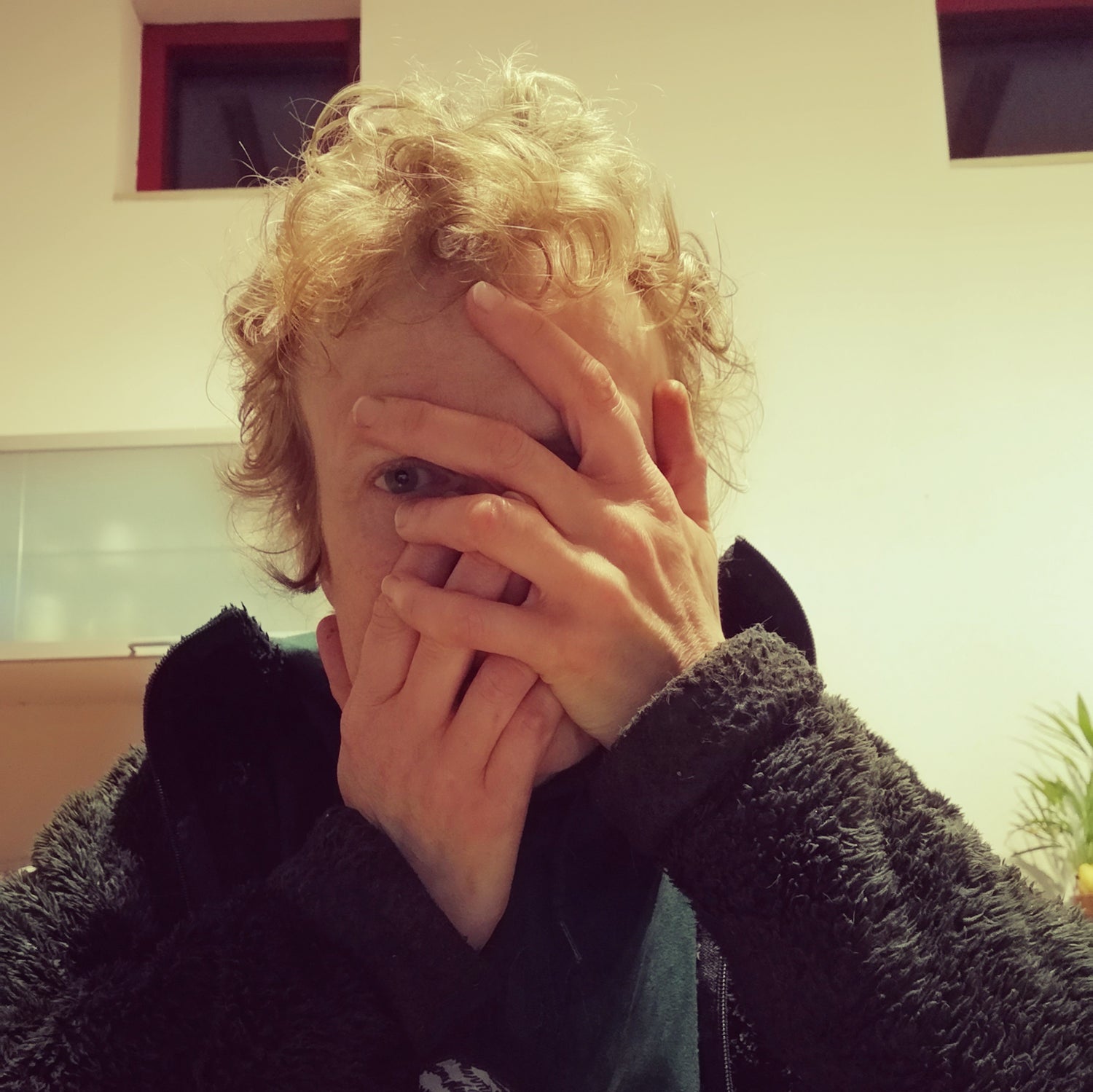 A close-up photo of Maartje with hands partially covering her face, expressing a moment of emotional intensity. This image accompanies a personal story about chronic pain and emotional healing.